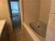 A tiled bathroom featuring a bathtub and a peek into the toilet area at 4122 N Lockwood Ridge Rd, Sarasota, FL 34234