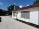 This exterior view features a white home with a gray window and gravel around it at 4122 N Lockwood Ridge Rd, Sarasota, FL 34234