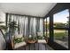 Screened in porch with neutral colored cushions and throw pillows and views of lush landscaping at 4153 66Th Street W Cir # 4153, Bradenton, FL 34209