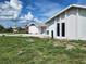 Exterior view of a white stucco home with green lawn and bright blue sky at 4354 Rock Creek Dr, Port Charlotte, FL 33948