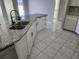 View of kitchen island with double sink, granite countertops, and white cabinetry at 4354 Rock Creek Dr, Port Charlotte, FL 33948