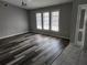 Open living room with hardwood-style floors, a modern chandelier, and lots of light from the big windows at 4354 Rock Creek Dr, Port Charlotte, FL 33948