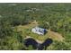 Secluded property nestled amidst mature trees, offering privacy and a serene pond at 4888 Old Ranch Rd, Sarasota, FL 34241