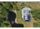 Aerial view showcasing a house with solar panels next to a pond at 4888 Old Ranch Rd, Sarasota, FL 34241