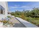 Backyard with a pond, grassy area, rock pathway, wooden deck and chairs, and lush greenery at 4888 Old Ranch Rd, Sarasota, FL 34241