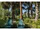 Relaxing backyard seating area surrounded by palm trees and lush greenery creating a tranquil outdoor space at 4888 Old Ranch Rd, Sarasota, FL 34241