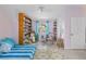 Bright bedroom with unique decor, built-in bookcase, window view, and comfy bed and a comfy chair at 4888 Old Ranch Rd, Sarasota, FL 34241