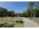 Long driveway lined with a wooden fence, leading to a secluded home surrounded by mature trees at 4888 Old Ranch Rd, Sarasota, FL 34241