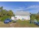 Exterior shot featuring a two-car garage with a well-maintained lawn, a golf cart, and blue Volkswagen Beetle at 4888 Old Ranch Rd, Sarasota, FL 34241