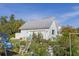 Exterior shot of the two-car garage with a manicured lawn, surrounded by green plants and outdoor furniture at 4888 Old Ranch Rd, Sarasota, FL 34241
