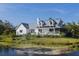Charming white home featuring a welcoming front porch and serene pond with fountain at 4888 Old Ranch Rd, Sarasota, FL 34241