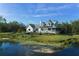 Serene home featuring a pond and a well-kept lawn with mature landscaping at 4888 Old Ranch Rd, Sarasota, FL 34241