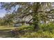 A large oak tree with a white home in the background at 4888 Old Ranch Rd, Sarasota, FL 34241