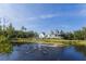 Picturesque home overlooking a pond with a fountain, complemented by lush landscaping and a serene natural setting at 4888 Old Ranch Rd, Sarasota, FL 34241