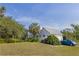 View of the side of the home, with a screened in porch, and a well-manicured yard at 4888 Old Ranch Rd, Sarasota, FL 34241