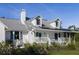 Inviting two-story home with solar panels, a welcoming porch, and lush landscaping for added curb appeal at 4888 Old Ranch Rd, Sarasota, FL 34241