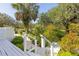 Pictureque landscaping with a stone path and green foliage near a white wooden stairway and deck at 4888 Old Ranch Rd, Sarasota, FL 34241