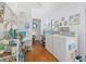Bright laundry room with white washer and dryer, colorful decor and wood floors, blending function with a playful aesthetic at 4888 Old Ranch Rd, Sarasota, FL 34241
