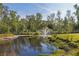 Scenic pond featuring a fountain, surrounded by trees and lush greenery, creating a peaceful ambiance at 4888 Old Ranch Rd, Sarasota, FL 34241