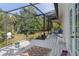 Inviting screened porch with white decor and an enchanting view of the property's lush yard at 4888 Old Ranch Rd, Sarasota, FL 34241