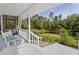 Inviting porch with seating overlooking a tranquil pond featuring a fountain and lush green surroundings at 4888 Old Ranch Rd, Sarasota, FL 34241