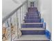 Staircase with unique blue tile risers, light wood treads, and decorative vases, adding artistic flair to the home at 4888 Old Ranch Rd, Sarasota, FL 34241
