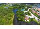 Aerial view of the Turtle Rock community featuring mature landscaping, a lake, and tennis courts at 5080 Timber Chase Way, Sarasota, FL 34238