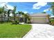Beautiful single-story home with a well-manicured lawn, paver driveway and lush landscaping at 5080 Timber Chase Way, Sarasota, FL 34238
