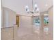 Bright living room with tile floors and modern chandelier overlooks the screened-in pool at 5080 Timber Chase Way, Sarasota, FL 34238