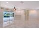 Living room with tile flooring and sliding glass doors opening to a screened-in pool at 5080 Timber Chase Way, Sarasota, FL 34238