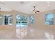 Living room featuring tile floors, ceiling fan, and sliding doors with a screened-in pool view at 5080 Timber Chase Way, Sarasota, FL 34238