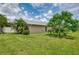 Expansive backyard featuring lush lawn, mature trees, and partial view of the home's exterior at 5124 Palm Aire Dr, Sarasota, FL 34243