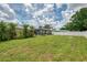 Lush backyard with a screen enclosed pool area surrounded by a well-maintained lawn and a privacy fence at 5124 Palm Aire Dr, Sarasota, FL 34243