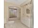 Bathroom featuring a tub under an arched window and toilet on tiled floor at 5124 Palm Aire Dr, Sarasota, FL 34243