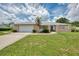 Charming one-story home with a well-manicured lawn, mature landscaping and a two-car garage at 5124 Palm Aire Dr, Sarasota, FL 34243