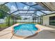 Aerial view of refreshing in-ground pool with screened in enclosure and open sky at 5124 Palm Aire Dr, Sarasota, FL 34243