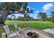 Spacious backyard featuring a fire pit, seating area, and expansive views of the golf course at 538 Magellan Dr, Sarasota, FL 34243