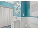 Bright bathroom with an oval mirror, pedestal sink, and white wainscoting at 538 Magellan Dr, Sarasota, FL 34243