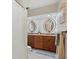 Bright bathroom features double sink, granite countertop, and decorative mirrors at 538 Magellan Dr, Sarasota, FL 34243