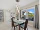 Bright dining area featuring modern lighting fixture, large window and stylish decor at 538 Magellan Dr, Sarasota, FL 34243