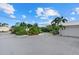 Circular driveway featuring meticulously manicured landscaping and a white metal roof at 538 Magellan Dr, Sarasota, FL 34243
