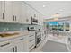 Modern kitchen featuring white cabinets, sleek black hardware, stainless appliances and water-view dining at 538 Magellan Dr, Sarasota, FL 34243