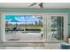 Open glass doors lead to a tranquil pool area with comfortable seating and golf course views at 538 Magellan Dr, Sarasota, FL 34243