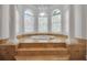 Stunning bathroom highlighting an elevated soaking tub with arched windows, and grand columns at 550 Dove Pointe, Osprey, FL 34229