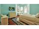 Light-filled bedroom with a seating area, hardwood floors, and large windows providing ample natural light at 550 Dove Pointe, Osprey, FL 34229