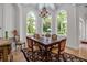 Bright dining room with a view of the palm trees, square table, and elegant chandelier at 550 Dove Pointe, Osprey, FL 34229