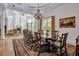 Large dining room with a long wooden table, ample seating, and views of the outdoors and swimming pool at 550 Dove Pointe, Osprey, FL 34229