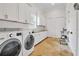 Functional laundry room with washer, dryer, storage cabinets, countertop space, and tile flooring at 550 Dove Pointe, Osprey, FL 34229