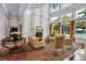 Inviting living room featuring a cozy fireplace, soaring ceilings, and large windows offering a view of the pool at 550 Dove Pointe, Osprey, FL 34229