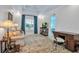 Bright living room featuring a comfortable couch, a desk, and a large window with blue curtains at 550 Dove Pointe, Osprey, FL 34229